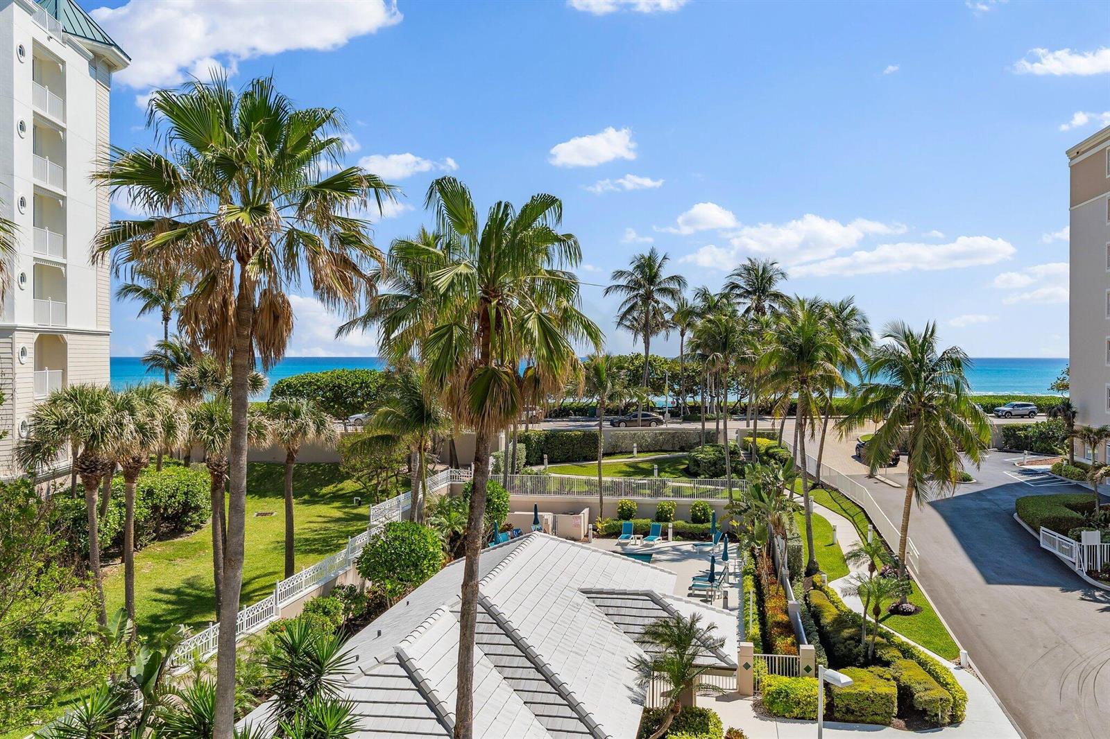 An elevated view of a coastal resort featuring palm trees, a pool area, and ocean views — 1660 S Highway A1a # 122, Jupiter FL 33477, JUPITER, FL