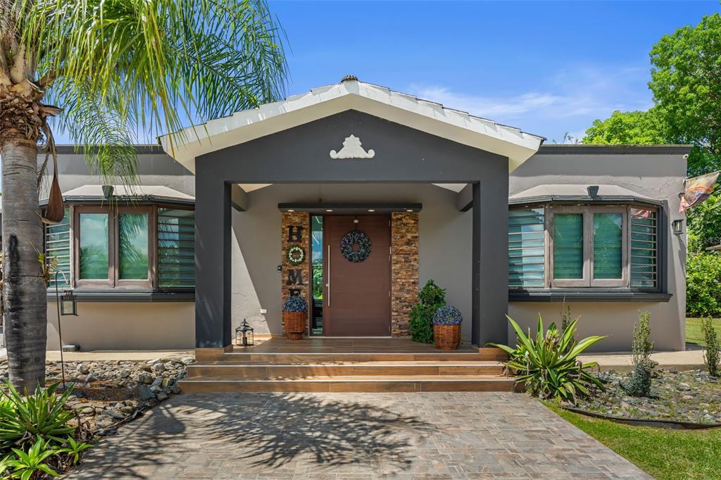 A single-story house with a dark gray entryway, stone accents, and a wooden front door — Carr 189 Km 16.9 BO CEIBA SUR, JUNCOS, PR