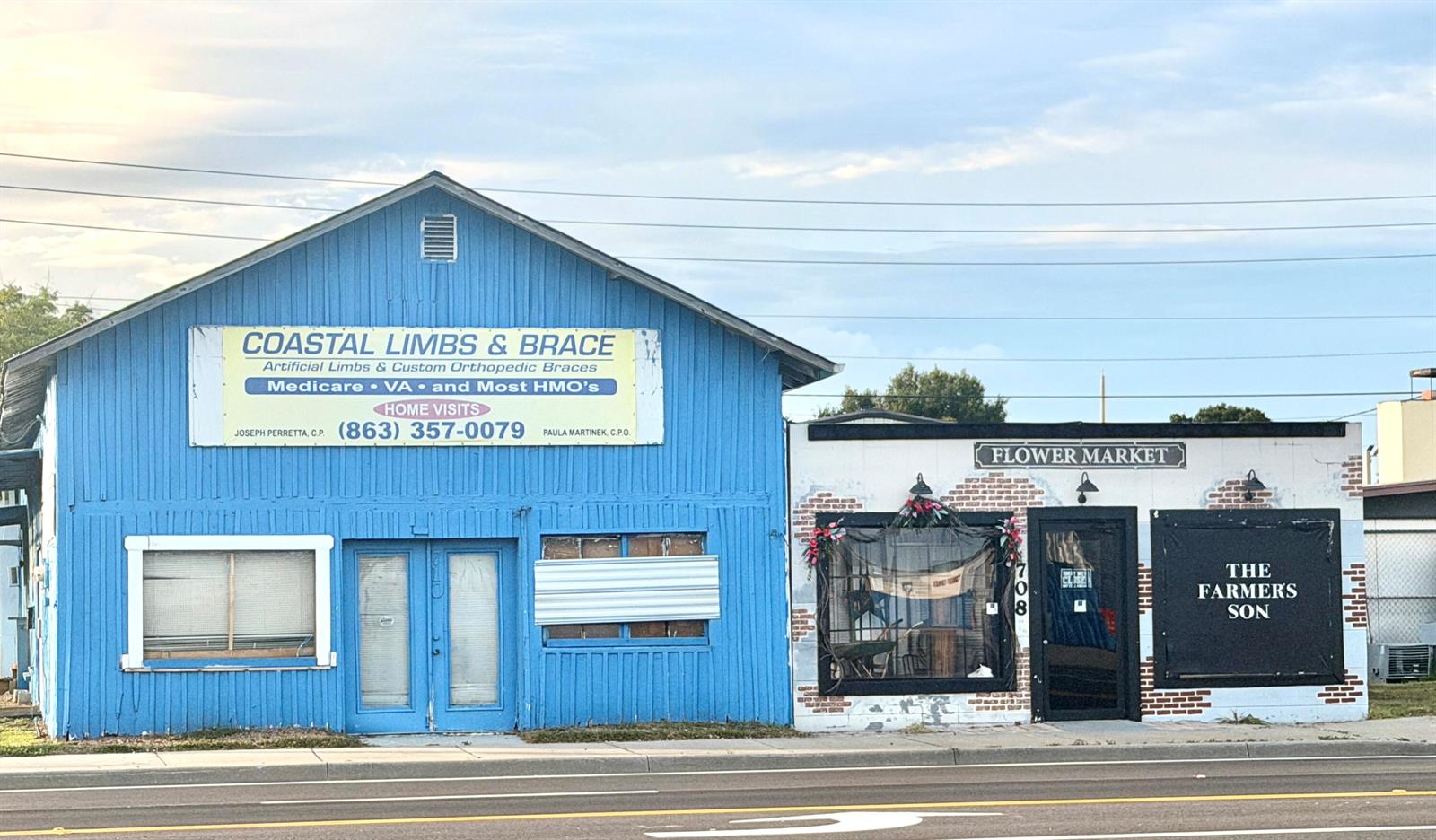 A blue building with a sign for Coastal Limbs & Brace sits beside a flower market — 710 NW Park Street, Okeechobee FL 34972, OKEECHOBEE, FL