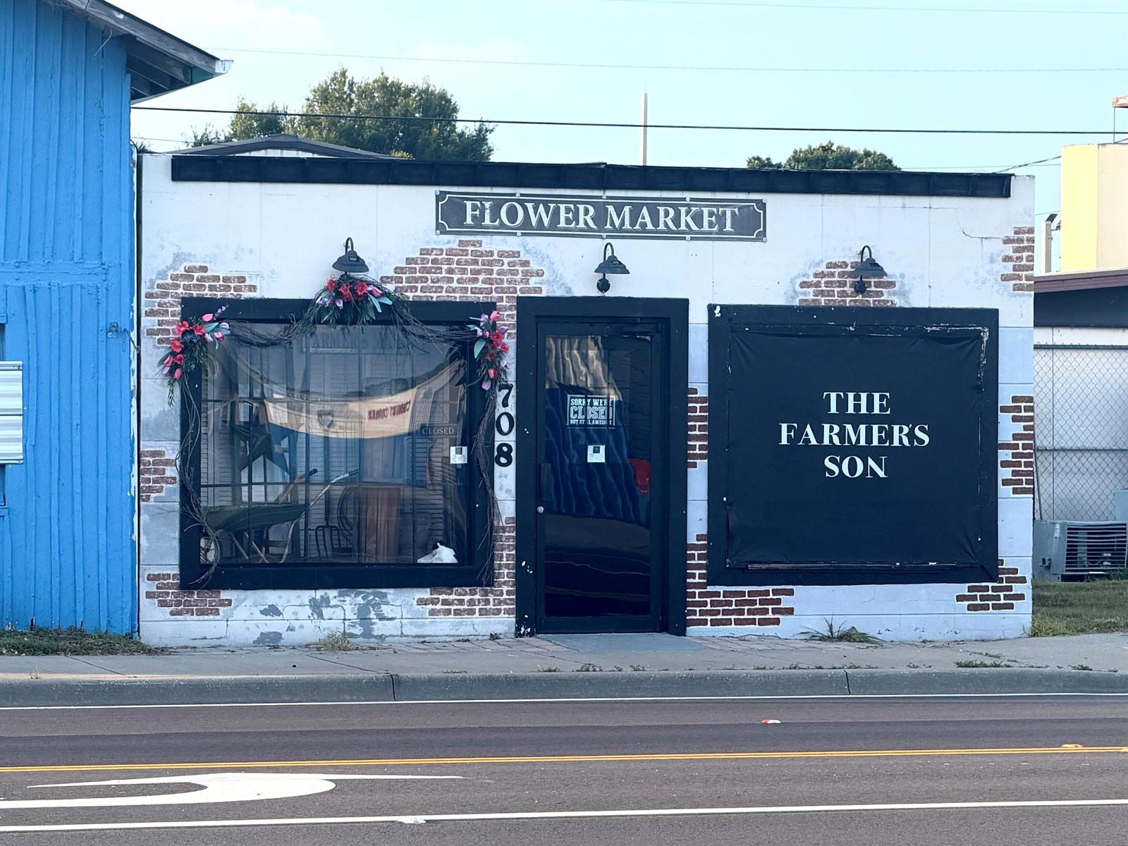 A single-story commercial building with a white brick facade, black trim, and signage for a flower market — 710 NW Park Street, Okeechobee FL 34972, OKEECHOBEE, FL