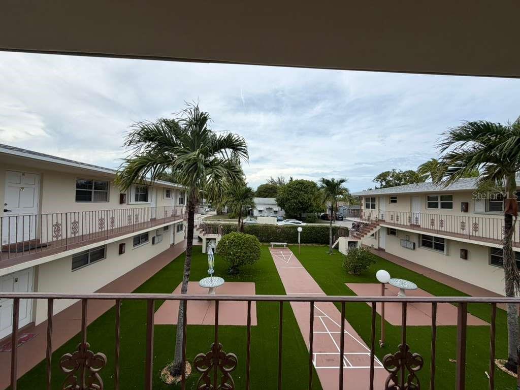 An elevated view of a courtyard between two apartment buildings with palm trees and walkways — 1710 MCKINLEY STREET UNIT 16, HOLLYWOOD, FL