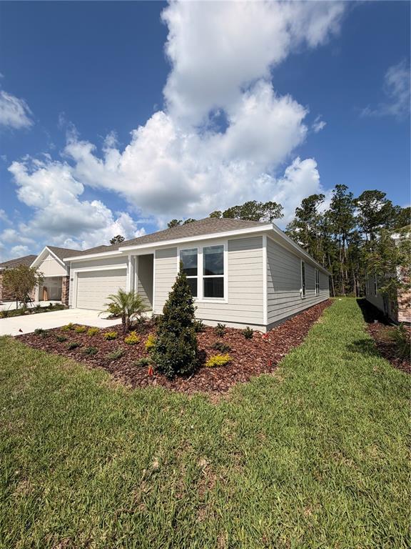 A light-colored, single-story house with a garage and a landscaped front yard — 5063 LOGGIA LANE UNIT A, KISSIMMEE, FL