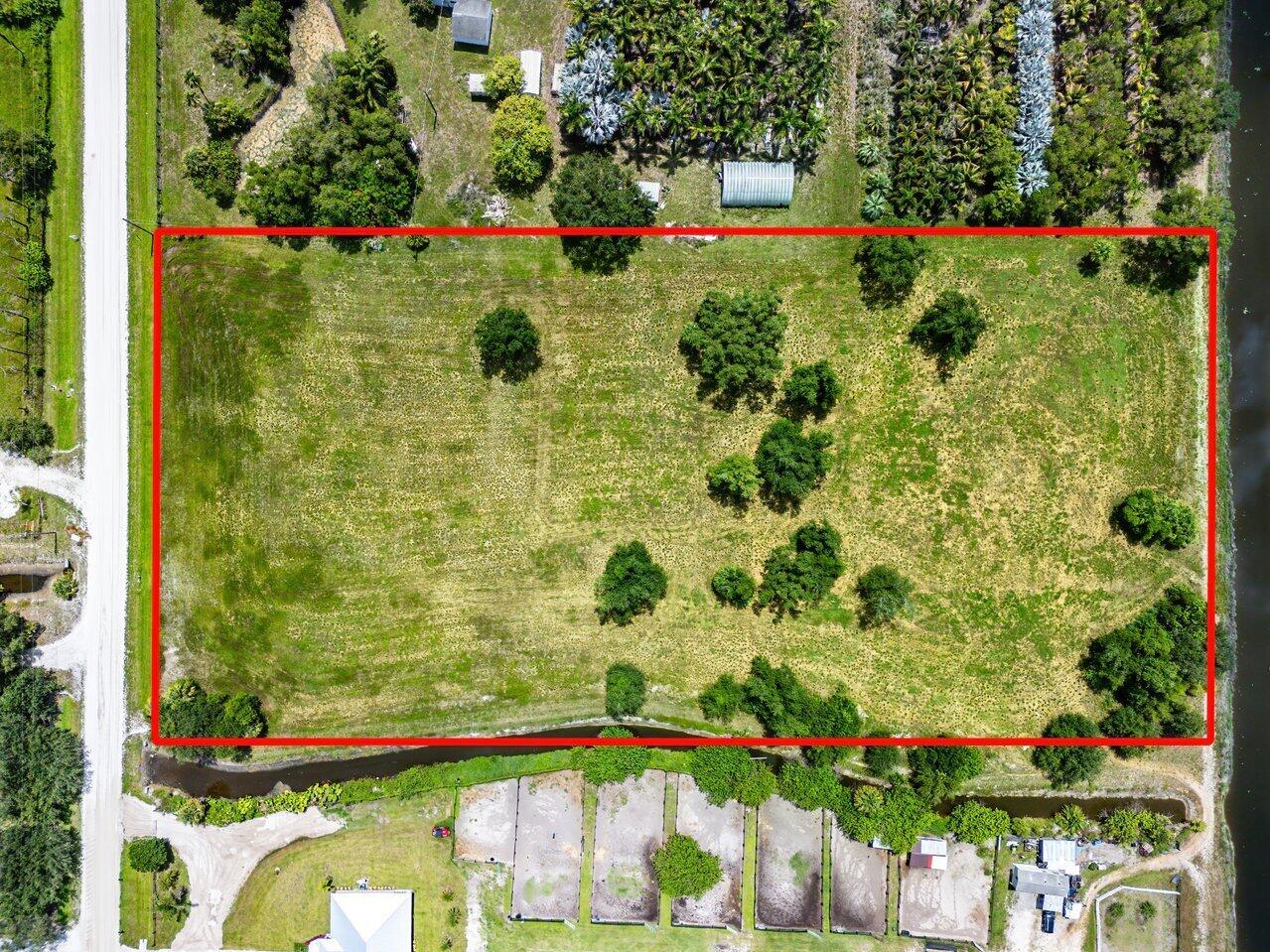An aerial view shows a rectangular, grassy vacant lot outlined in red next to a road — 16526 Hollow Tree Lane, Wellington FL 33470, WELLINGTON, FL