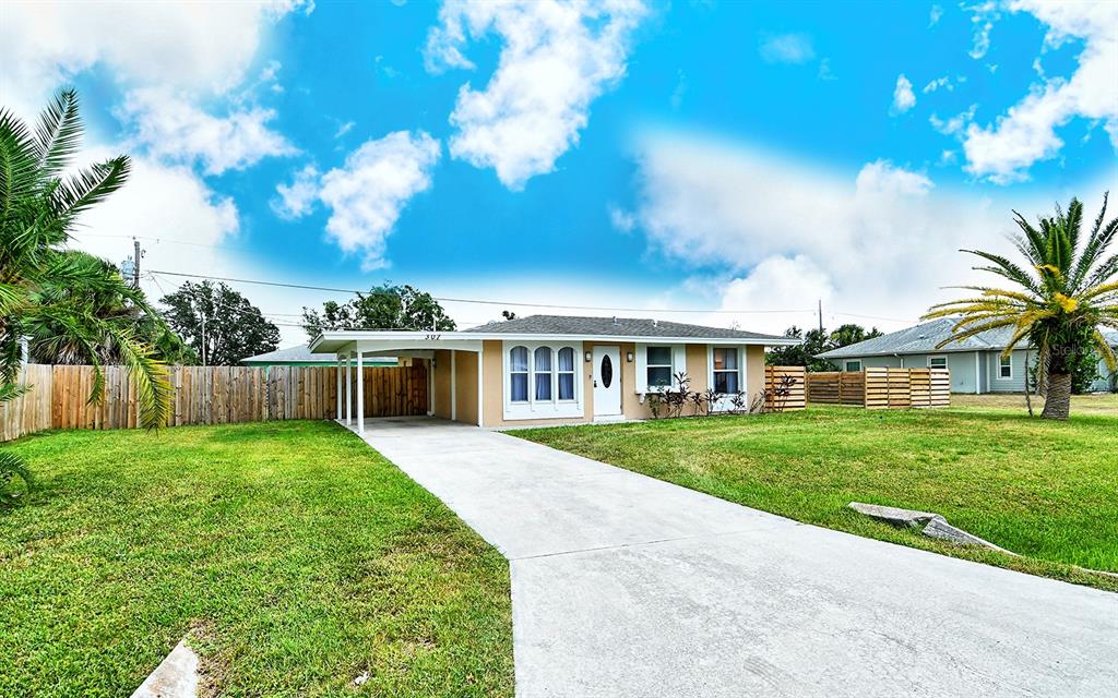 A single-story house with a carport, a concrete driveway, and a large front lawn — 307 SOUTHLAND ROAD, VENICE, FL