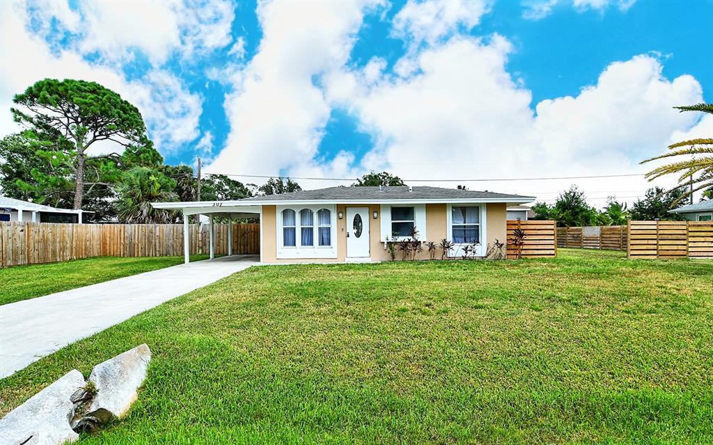 A single-story house with a carport, a white front door, and a wooden fence — 307 SOUTHLAND ROAD, VENICE, FL