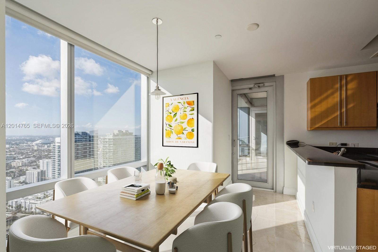 A dining area features a wooden table, six chairs, and floor-to-ceiling windows with city views — 1425 Brickell Ave # 57B, Miami FL 33131, MIAMI, FL