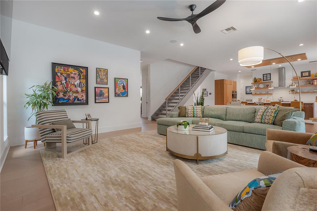 A living room features a light green sectional sofa, a round coffee table, and stairs — 4207 W JETTON AVENUE, TAMPA, FL