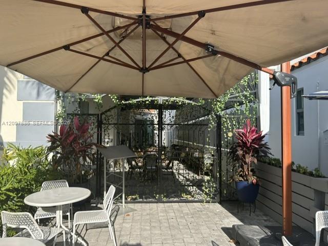 An outdoor patio features a large umbrella, dining tables, chairs, and potted plants — 929 Collins Ave, Miami Beach FL 33139, MIAMI BEACH, FL