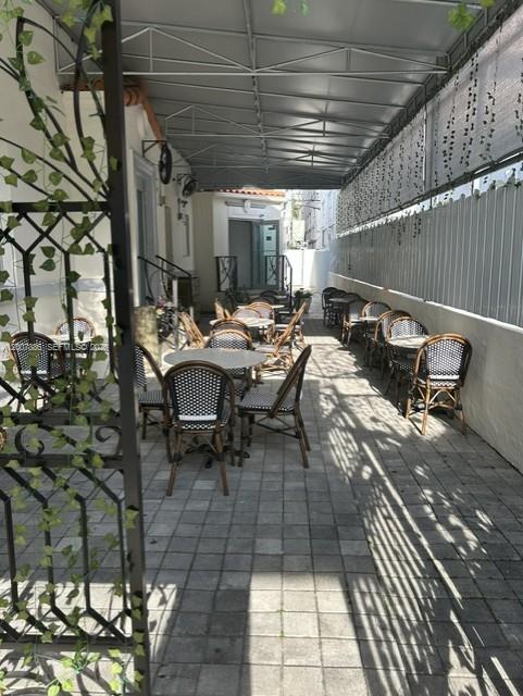 An outdoor patio features rows of tables and chairs under a covered metal awning — 929 Collins Ave, Miami Beach FL 33139, MIAMI BEACH, FL