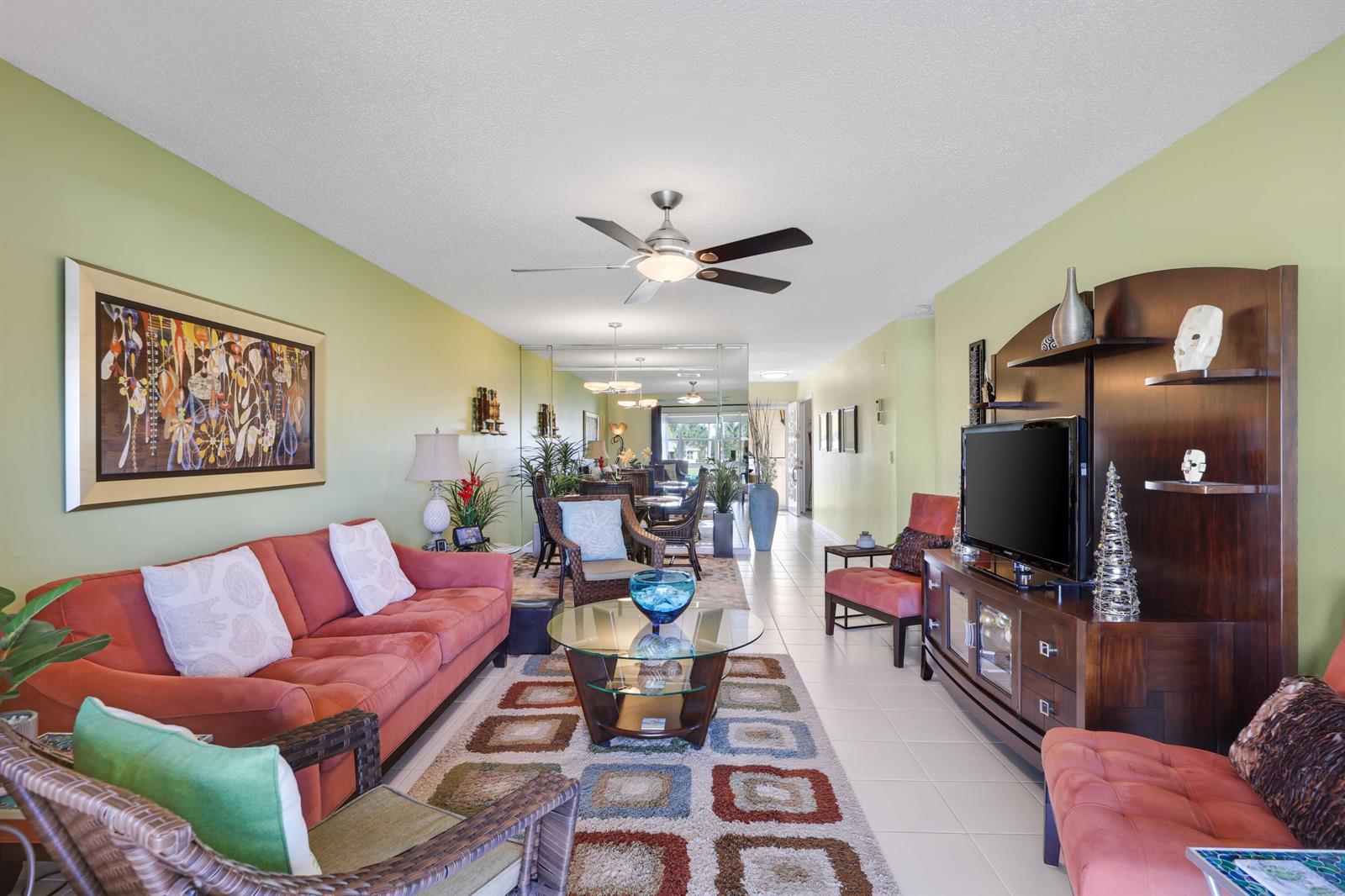 A living room features a coral sofa, a glass coffee table, and a media console — 13757 Flora Place, Delray Beach FL 33484, DELRAY BEACH, FL
