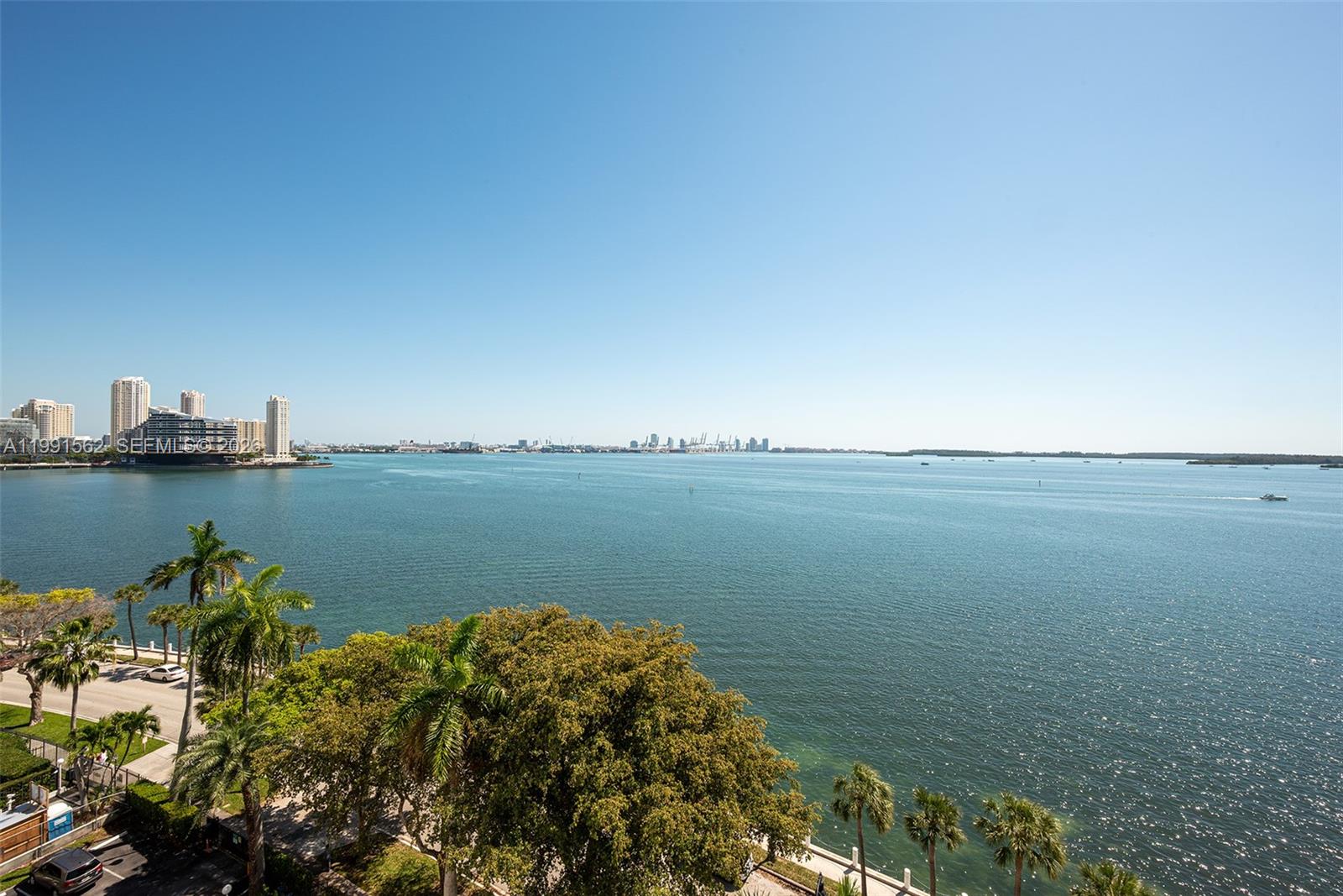 A high-angle view shows a calm bay with a city skyline in the distance — 1420 Brickell Bay Dr # 1003A, Miami FL 33131, MIAMI, FL