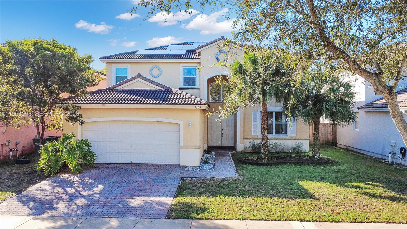 An aerial view shows several suburban houses with tiled roofs near a lake — 1604 SE 16th St, Homestead FL 33035, HOMESTEAD, FL