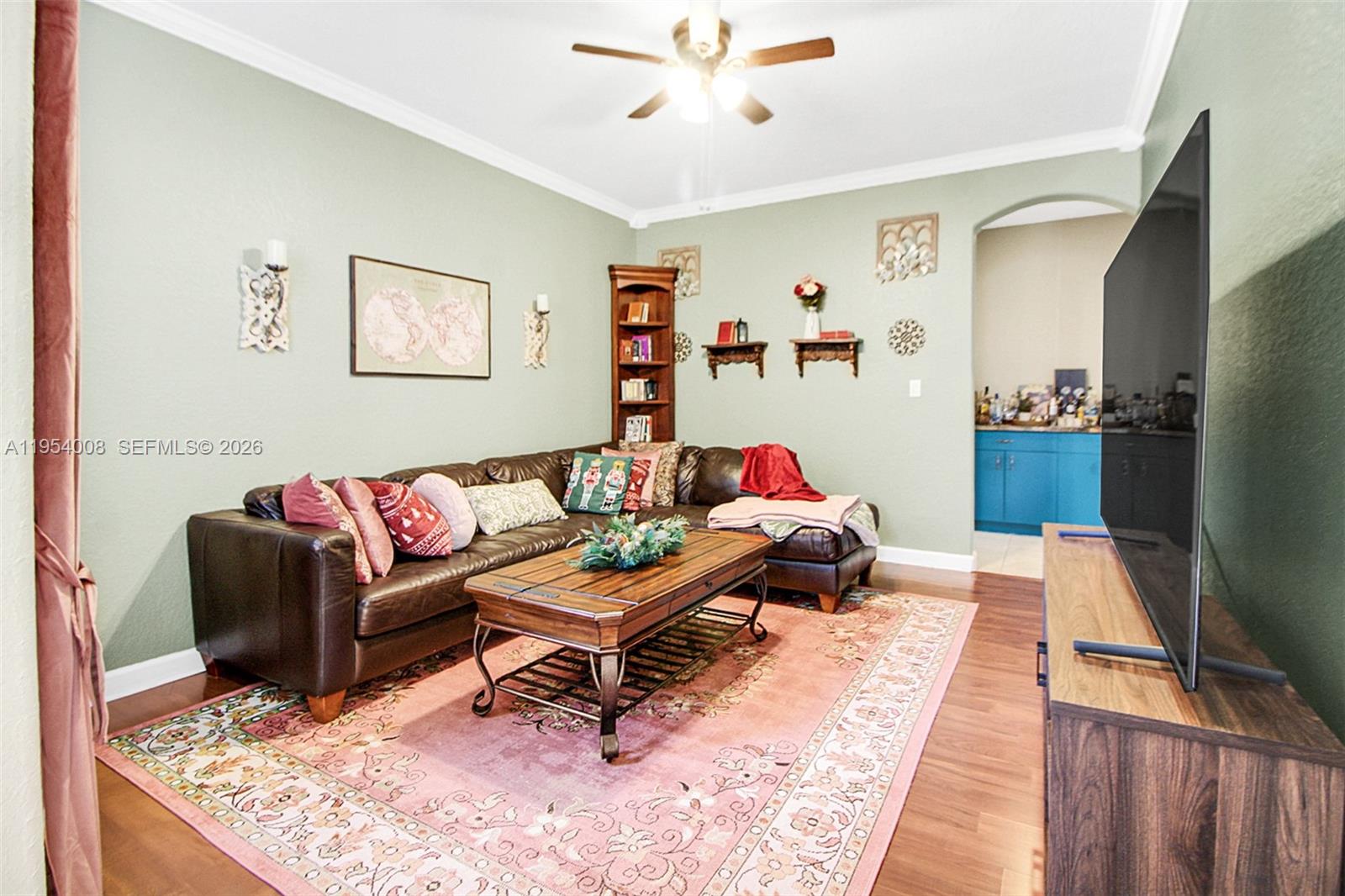 A dining area with a wooden table, red patterned rug, and tall sliding glass doors — 1604 SE 16th St, Homestead FL 33035, HOMESTEAD, FL