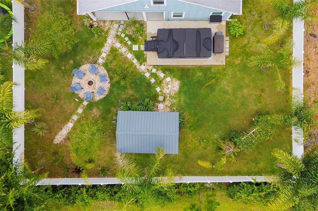 An aerial view of a backyard featuring a hot tub, fire pit, and storage shed — 17 ROCKWELL LANE, PALM COAST, FL