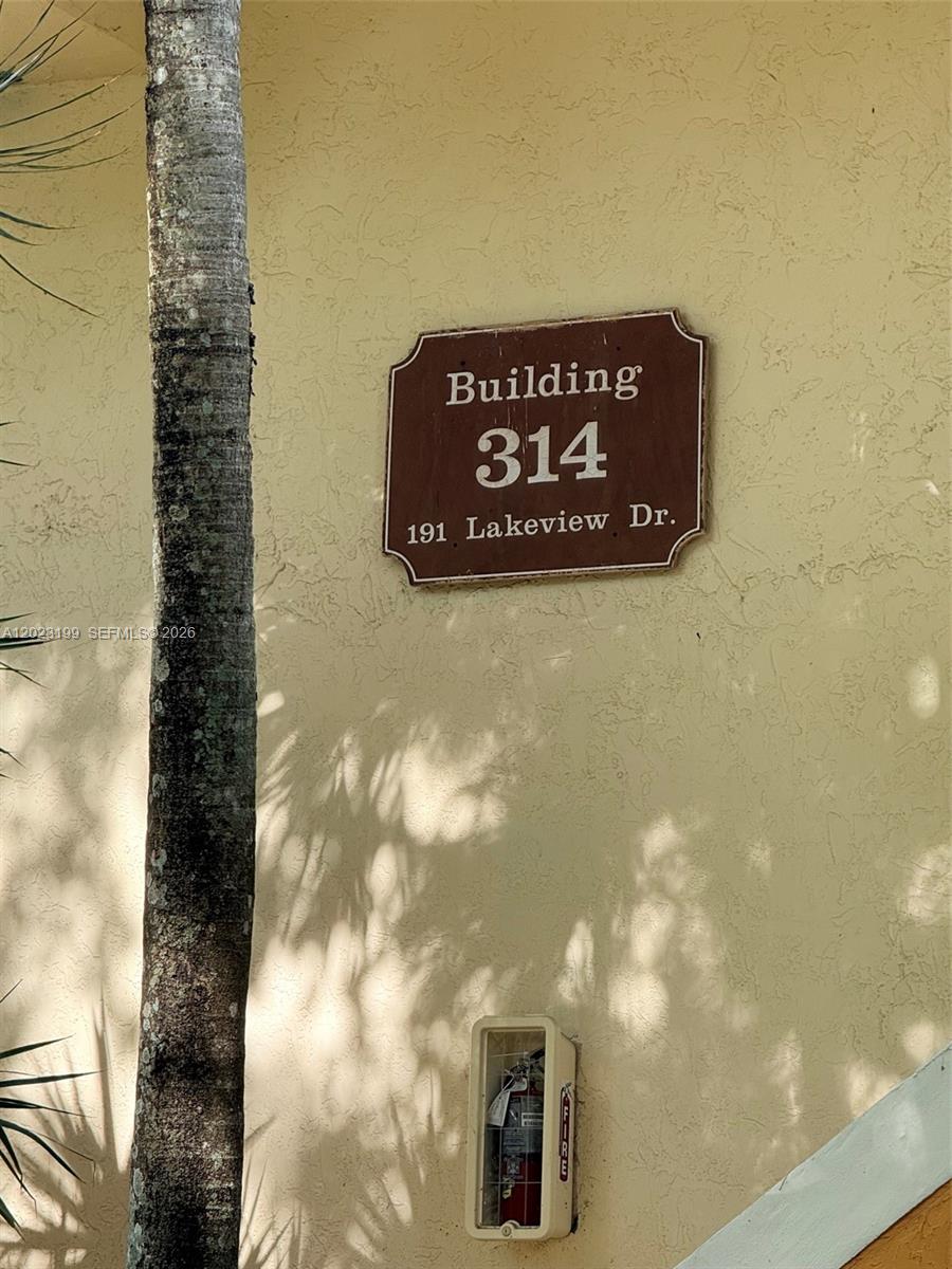 A sign for building 314 is mounted on a beige exterior wall near a fire extinguisher — 191 Lakeview Dr # 103, Weston FL 33326, WESTON, FL