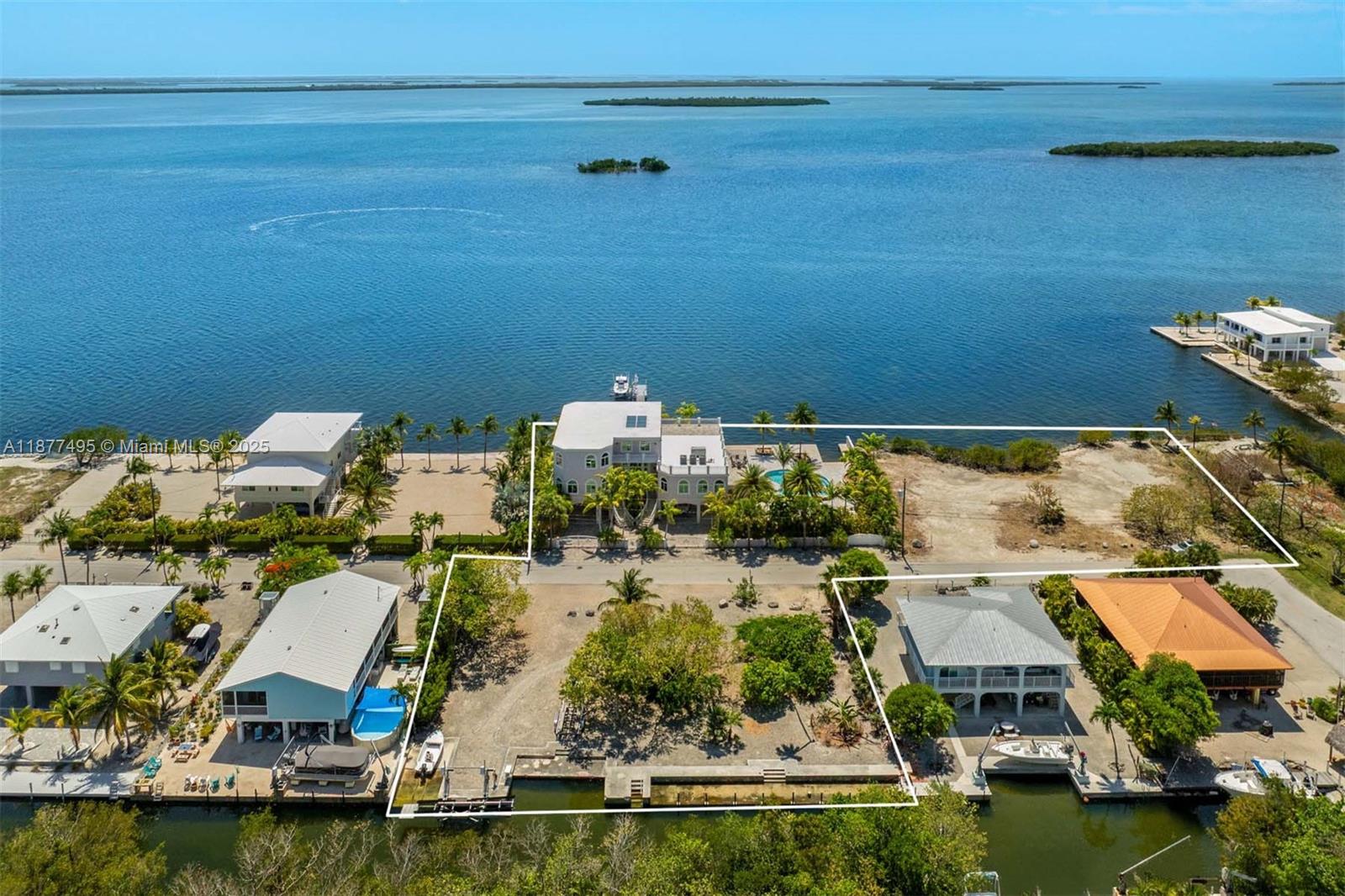 An aerial view shows multiple waterfront properties with docks, palm trees, and open land — 3742 Seagrape St, Big Pine FL 33043, BIG PINE, FL