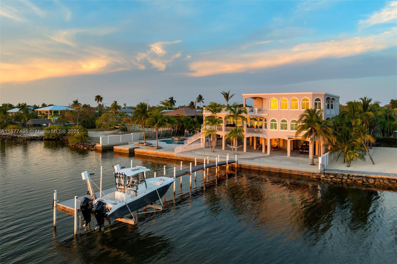 An aerial view of a multi-story waterfront home with a private dock and boat lift — 3742 Seagrape St, Big Pine FL 33043, BIG PINE, FL