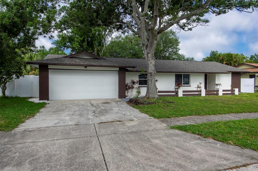 A single-story house with a white exterior, dark brown trim, and a two-car garage — 1689 MONTEREY DRIVE, CLEARWATER, FL