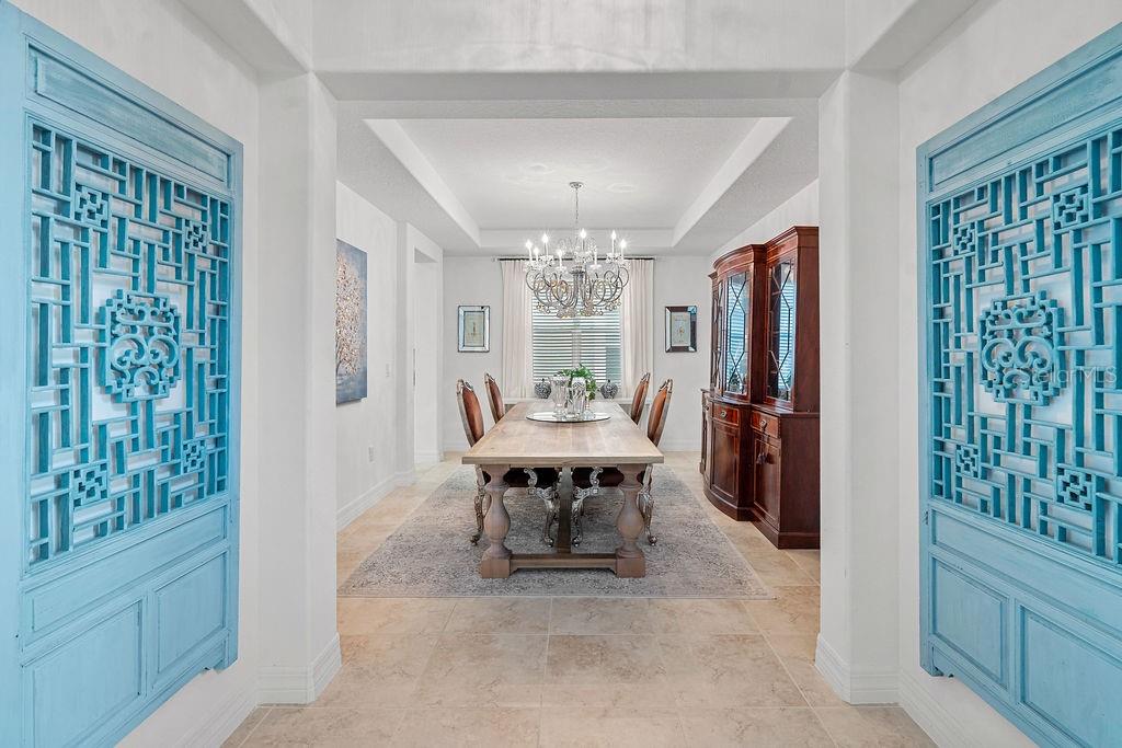 A bright entryway features high ceilings, tile flooring, a staircase, and a front door — 14897 ELLINGSWORTH LANE, WINTER GARDEN, FL