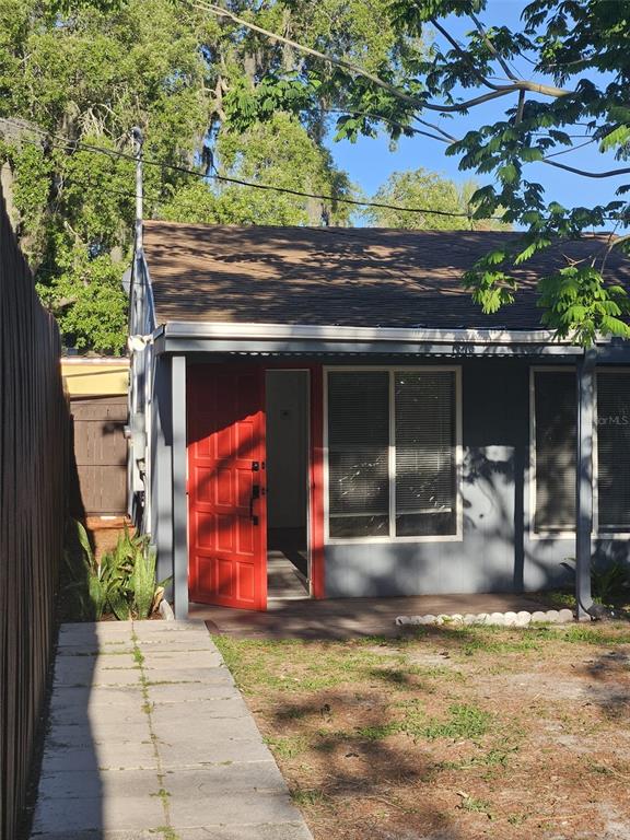 A small gray house features a bright red front door and a concrete walkway — 2387 SHERIDAN ROAD, MOUNT DORA, FL