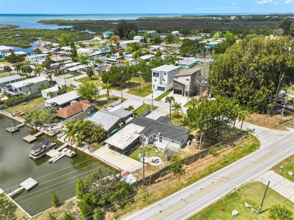 An aerial view shows a waterfront house with a boat dock along a canal — 7114 FAIR LANE, HUDSON, FL