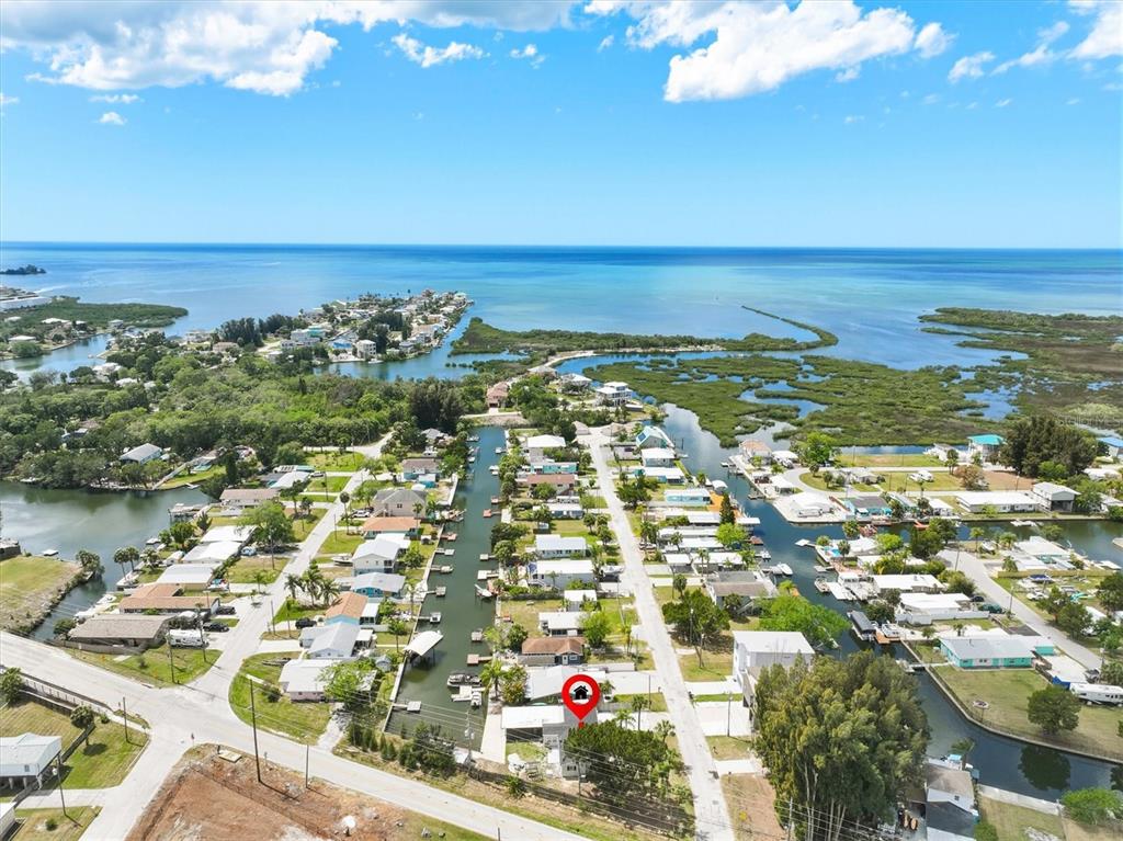 An aerial view shows a waterfront neighborhood with a red location marker on a house — 7114 FAIR LANE, HUDSON, FL
