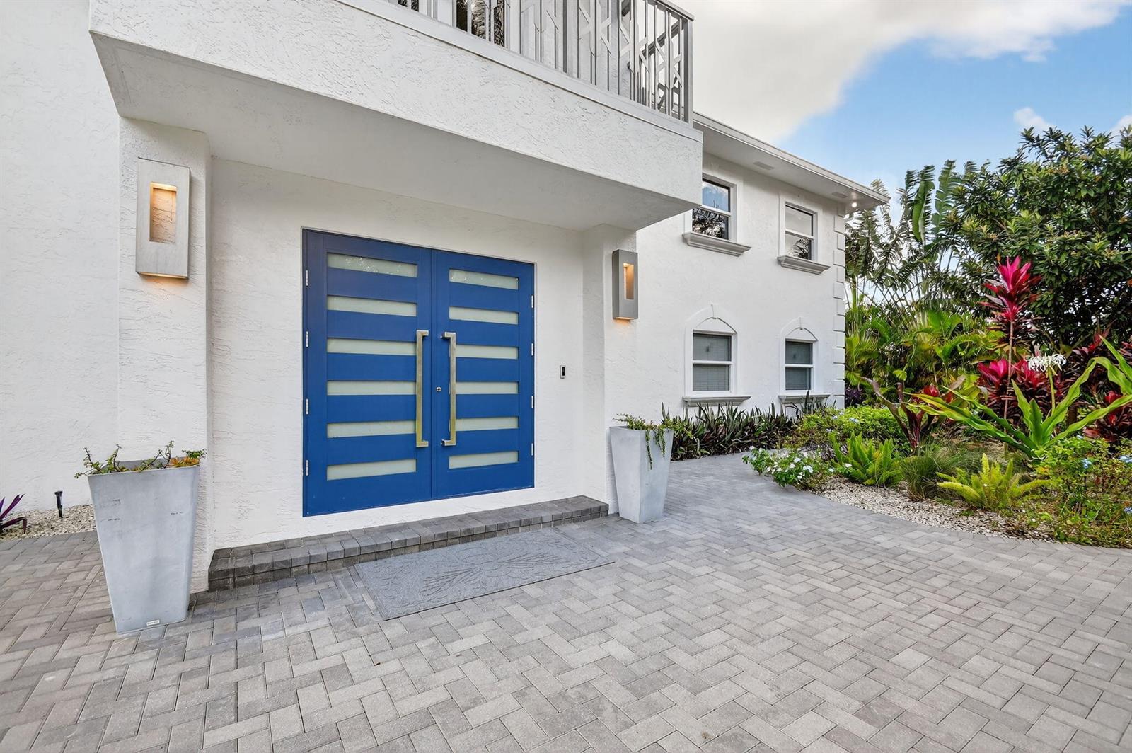 A white two-story house features a bright blue double front door with horizontal glass panels — 2900 Greenbriar Boulevard, Wellington FL 33414, WELLINGTON, FL