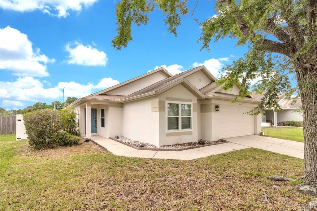 A single-story house with a beige stucco exterior, a two-car garage, and a front lawn — 8141 FORT THOMAS WAY, ORLANDO, FL