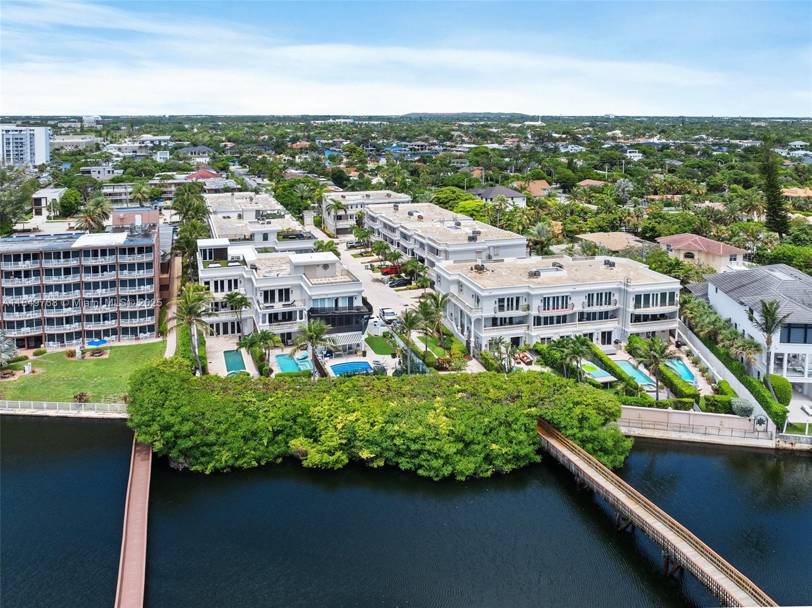 An aerial view shows multi-story residential buildings with swimming pools situated along a waterfront — 1784 Bay Dr # 1784, Pompano Beach FL 33062, POMPANO BEACH, FL