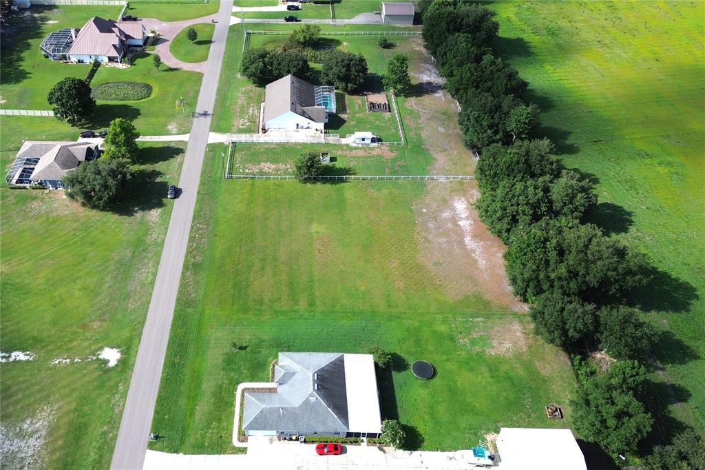 An aerial view shows several houses situated on large, grassy lots along a paved road — 14718 EVANS RANCH RD, LAKELAND, FL
