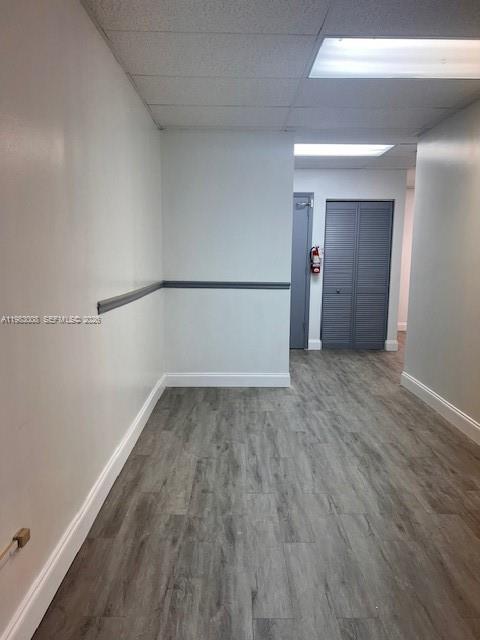 A hallway with light-colored walls, a chair rail, and wood-look flooring leads to a closet — 10500 NW 50th St # 102, Sunrise FL 33351, SUNRISE, FL