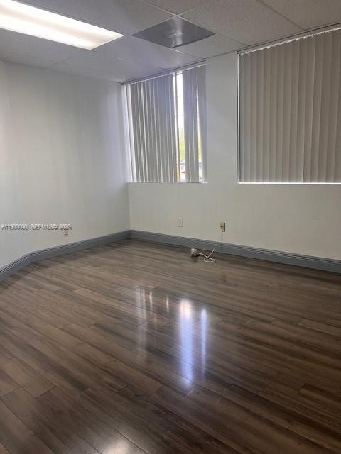 An empty office room features wood-look laminate flooring, white walls, and vertical window blinds — 10500 NW 50th St # 102, Sunrise FL 33351, SUNRISE, FL