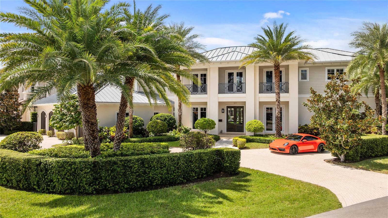A two-story house with a metal roof, palm trees, and an orange car parked outside — 3211 NE 27th Avenue, Lighthouse Point FL 33064, LIGHTHOUSE POINT, FL