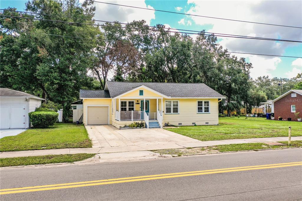 A yellow, single-story house with a front porch, attached garage, and a concrete driveway — 528 S INGRAHAM AVENUE, LAKELAND, FL
