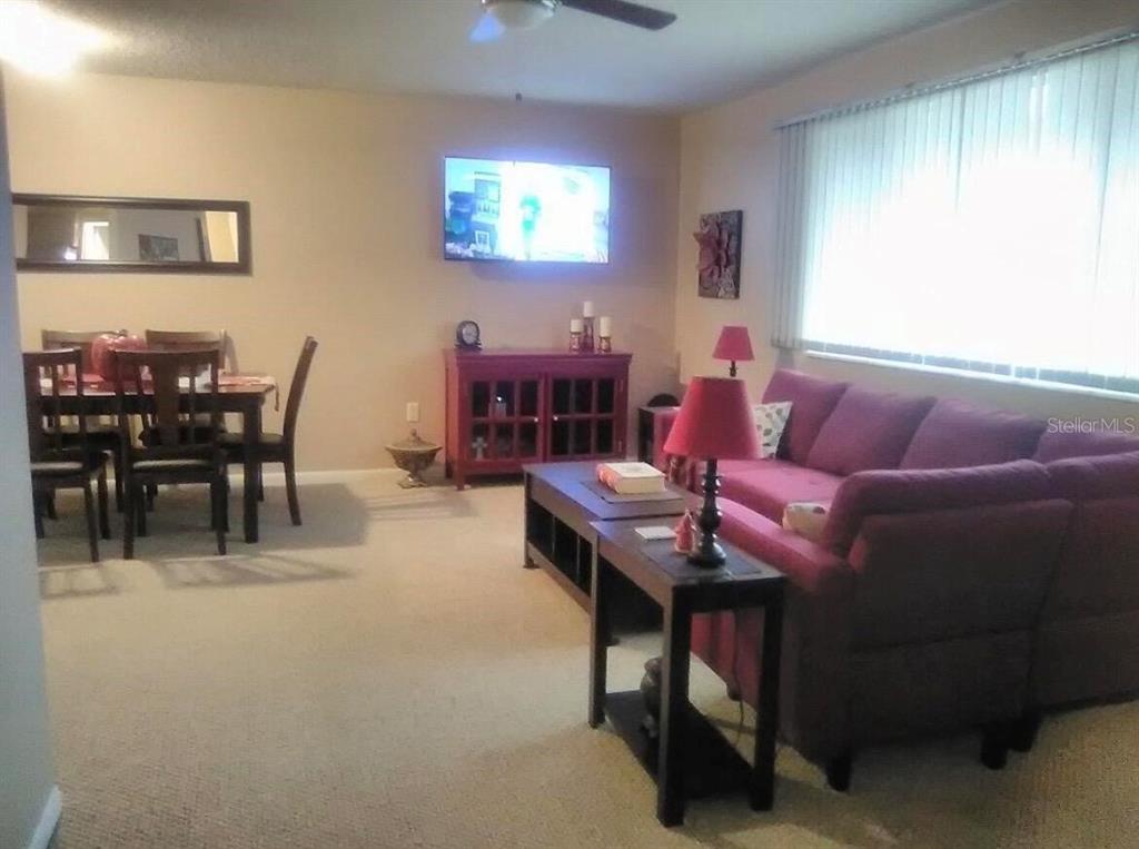 A living room features a purple sofa, a dining set, and a wall-mounted television — 8532 SW 109TH LANE ROAD, OCALA, FL