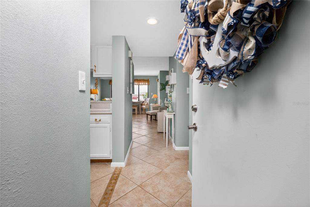 A view from an entryway into a hallway with tile floors and light-colored walls — 25188 MARION AVENUE UNIT F207, PUNTA GORDA, FL