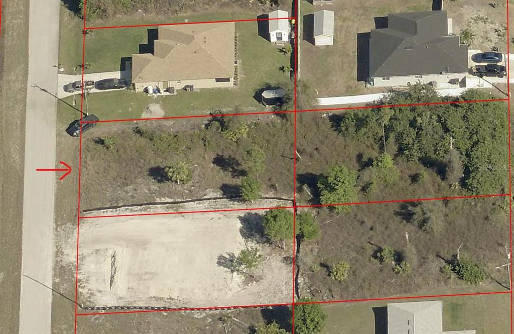 This aerial map shows several rectangular residential lots, including one cleared lot with a red arrow — 765 BIANCA AVENUE S, LEHIGH ACRES, FL