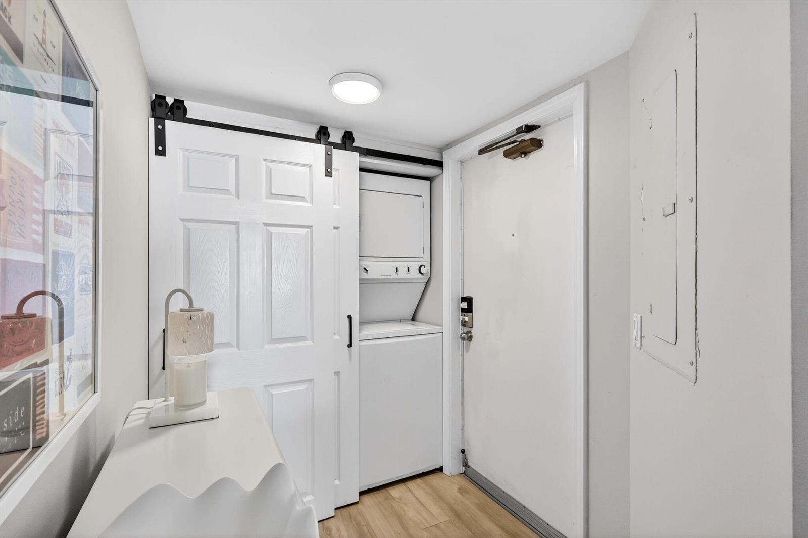 A laundry closet with a stacked washer and dryer sits beside an entry door — 9650 S Ocean Drive # 507, Jensen Beach FL 34957, JENSEN BEACH, FL