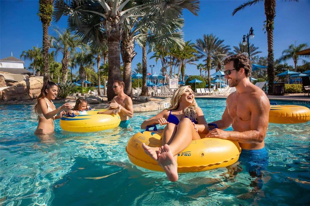 A group of people enjoy a sunny day in a resort swimming pool with yellow tubes — 7920 SPECTRUM DRIVE, KISSIMMEE, FL