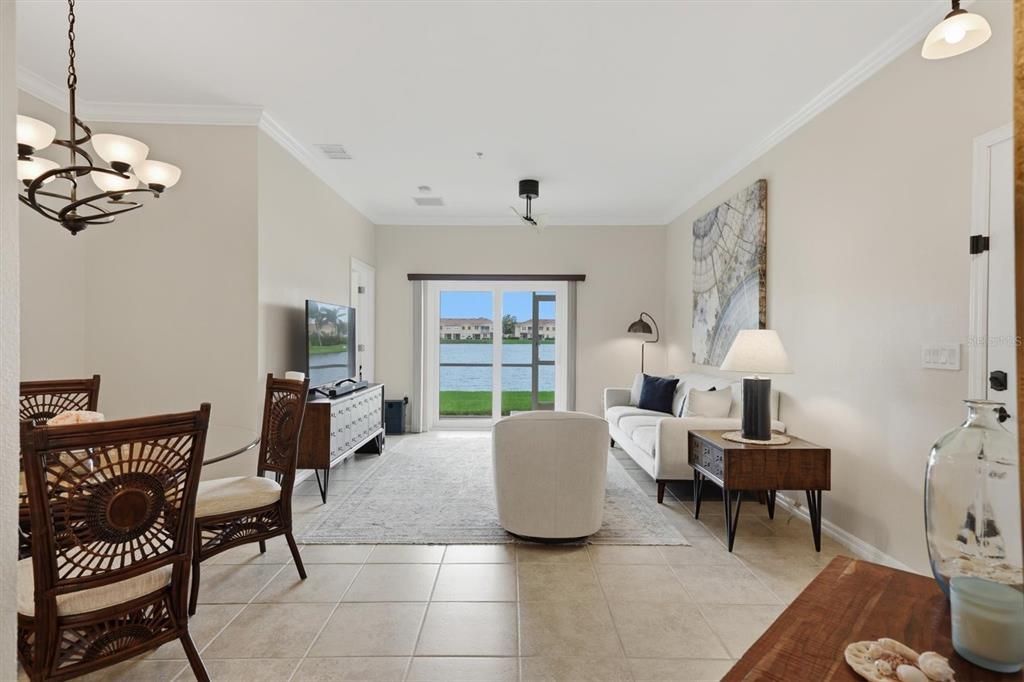 A living and dining area with tile floors, a ceiling fan, and a sliding glass door — 3582 PARKRIDGE CIRCLE UNIT 29-106, SARASOTA, FL