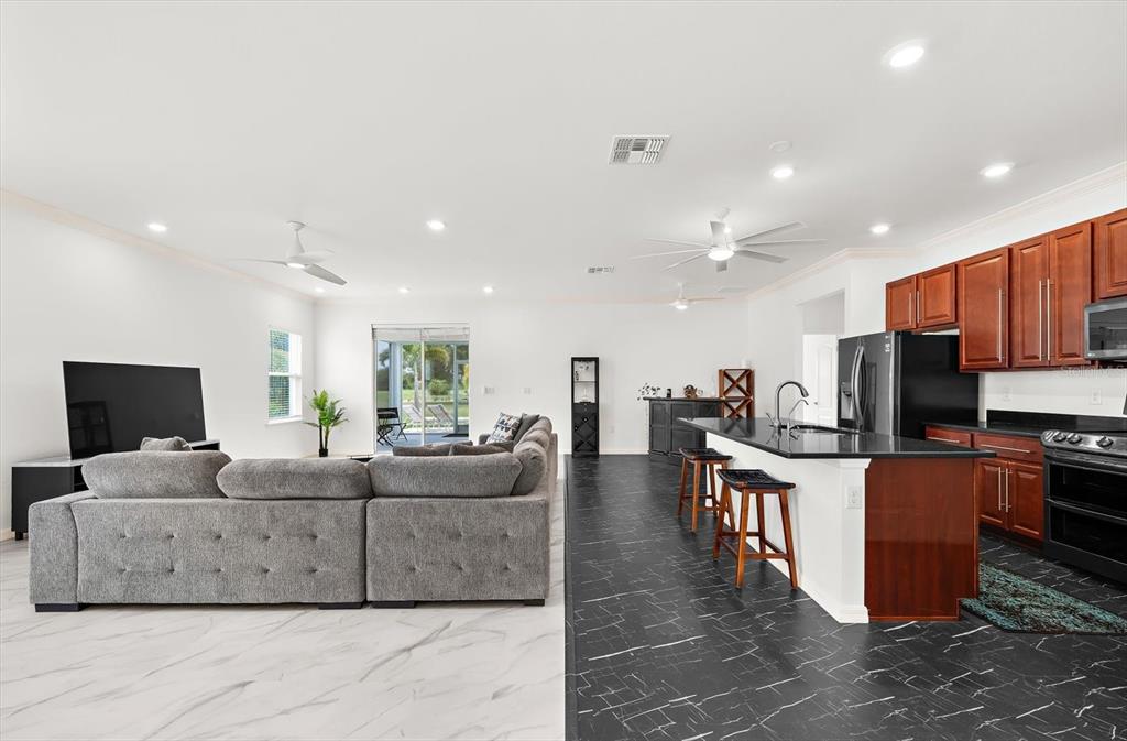 An open-concept living room and kitchen featuring contrasting white and black marble-look tile floors — 2365 MAURITANIA ROAD, PUNTA GORDA, FL