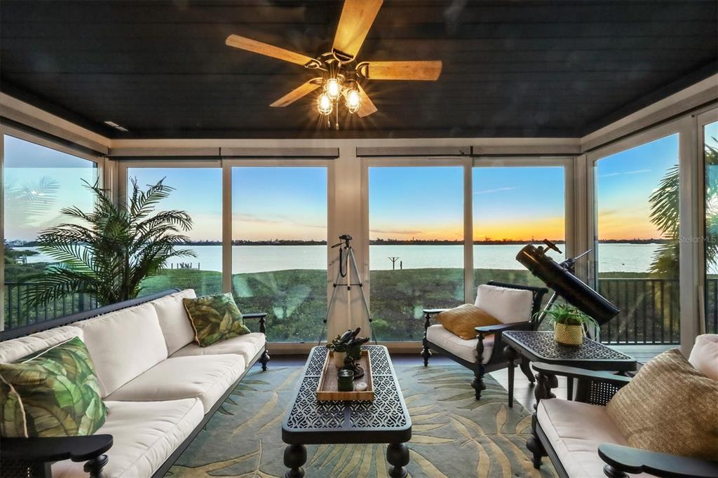 A sunroom with a dark ceiling, ceiling fan, and large windows overlooking a waterfront view — 9941 EAGLE PRESERVE DRIVE, ENGLEWOOD, FL