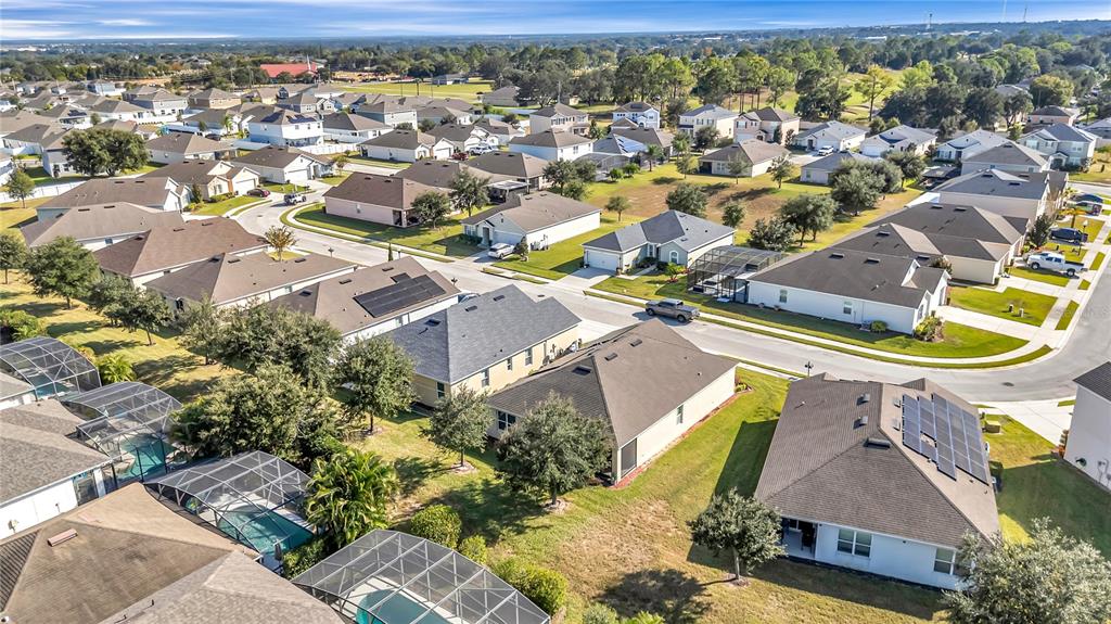 An aerial view shows a suburban neighborhood with single-family homes, swimming pools, and paved streets — 849 SHEEN CIRCLE, HAINES CITY, FL