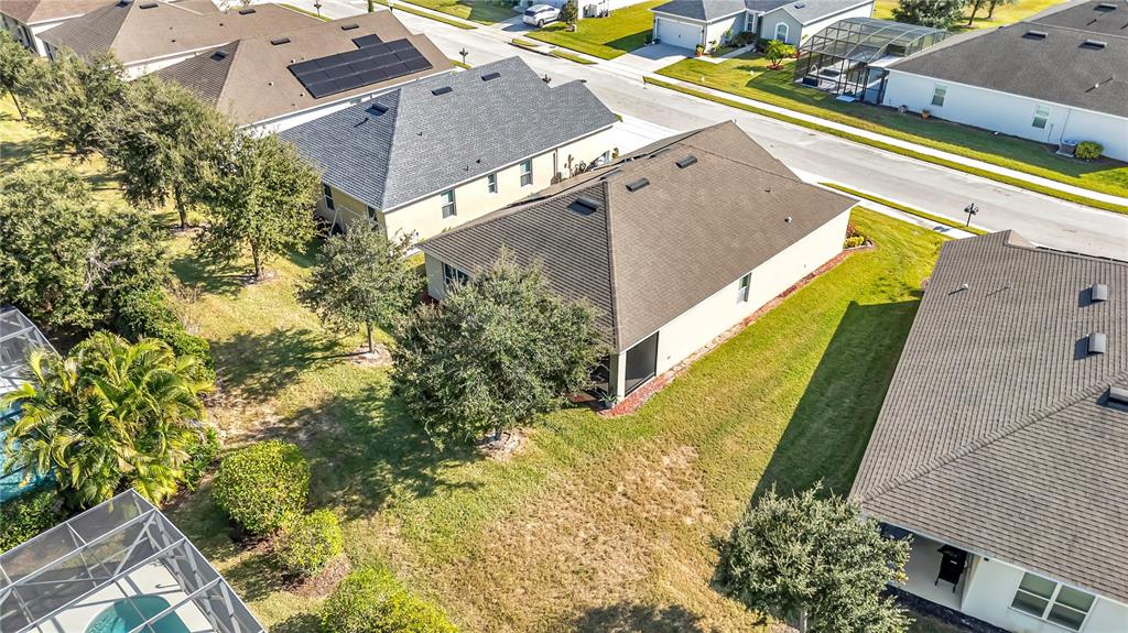 An aerial view shows several suburban houses with shingled roofs and surrounding grassy yards — 849 SHEEN CIRCLE, HAINES CITY, FL