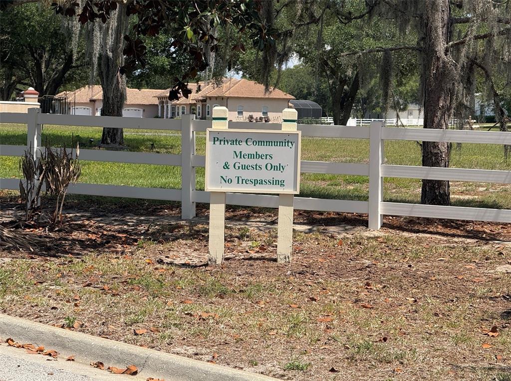 A sign reading Private Community Members & Guests Only stands before a white fence — 6115 RANCH LAKE ROAD, GROVELAND, FL