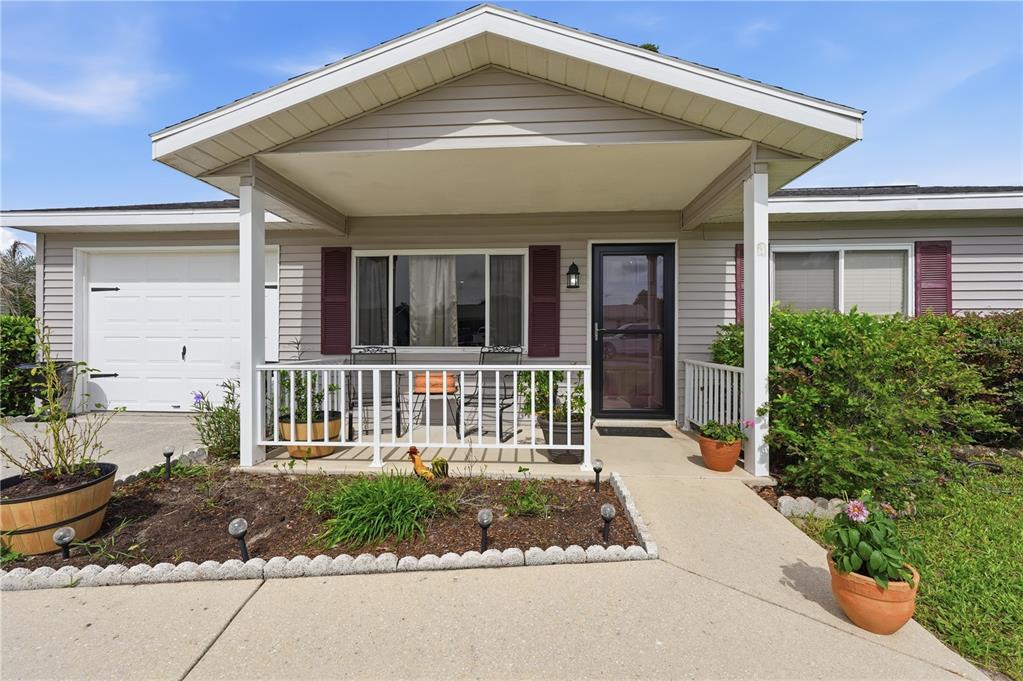 A single-story house with light gray siding, a covered front porch, and a concrete driveway — 11094 SW 79TH AVENUE, OCALA, FL