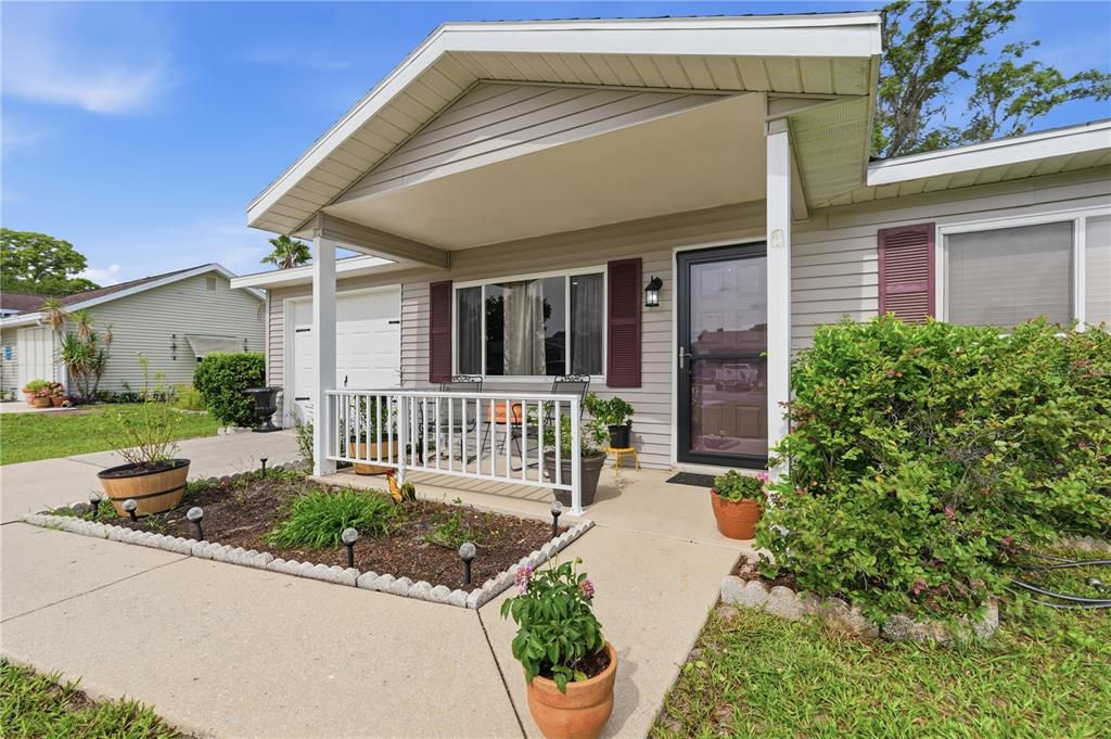 A single-story house with light gray siding, a covered front porch, and a concrete walkway — 11094 SW 79TH AVENUE, OCALA, FL