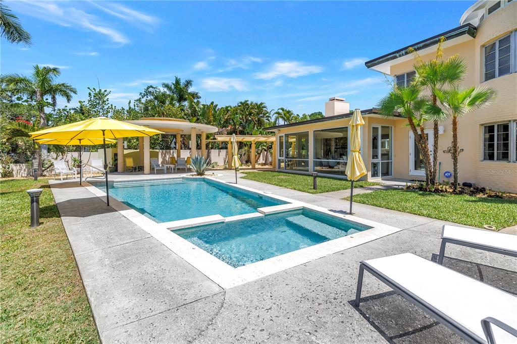 A backyard features a swimming pool with an attached spa, patio furniture, and palm trees — 2781 BAYSIDE DRIVE S, ST PETERSBURG, FL