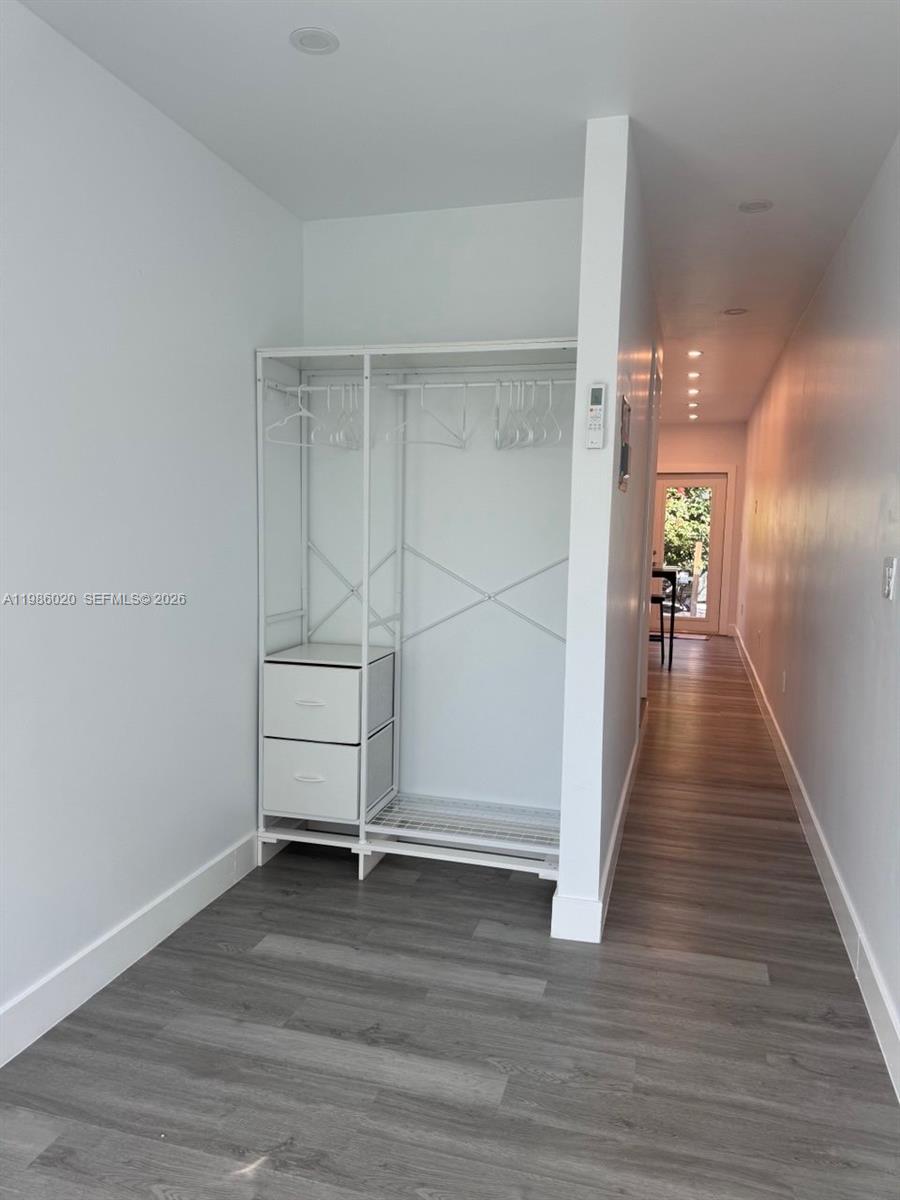 A white open wardrobe with two drawers stands in a hallway with wood-look flooring — 5800 SW 122nd Ave # 2, Miami FL 33183, MIAMI, FL