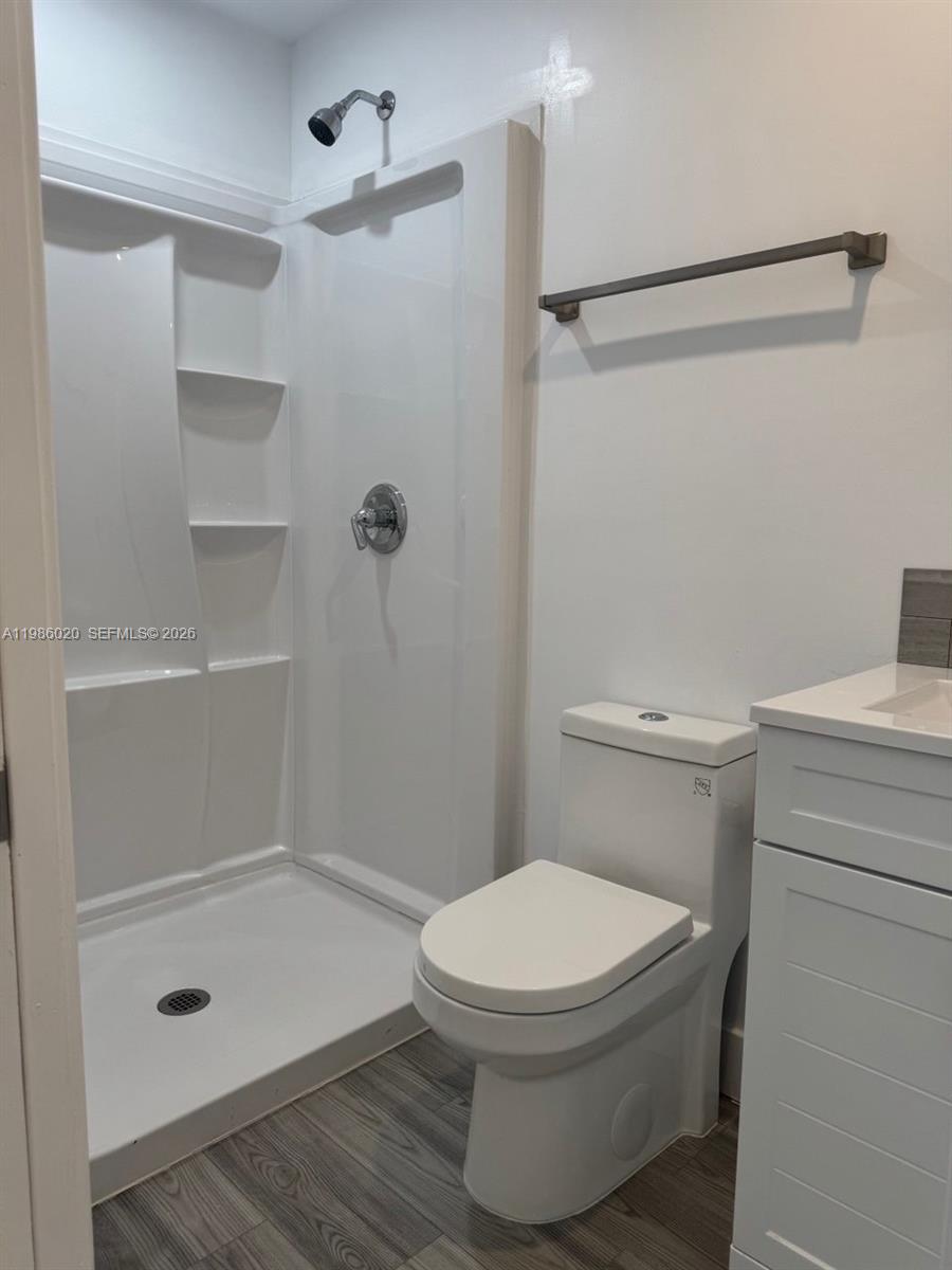 A bathroom features a white shower stall, a toilet, and a vanity with wood-look flooring — 5800 SW 122nd Ave # 2, Miami FL 33183, MIAMI, FL